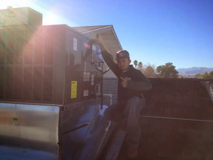 HVAC technician performing AC Tune-Up on a rooftop unit in Lely Resort